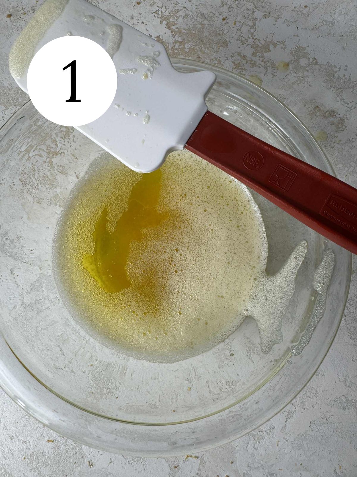 Brown butter in a glass bowl with a spatula.