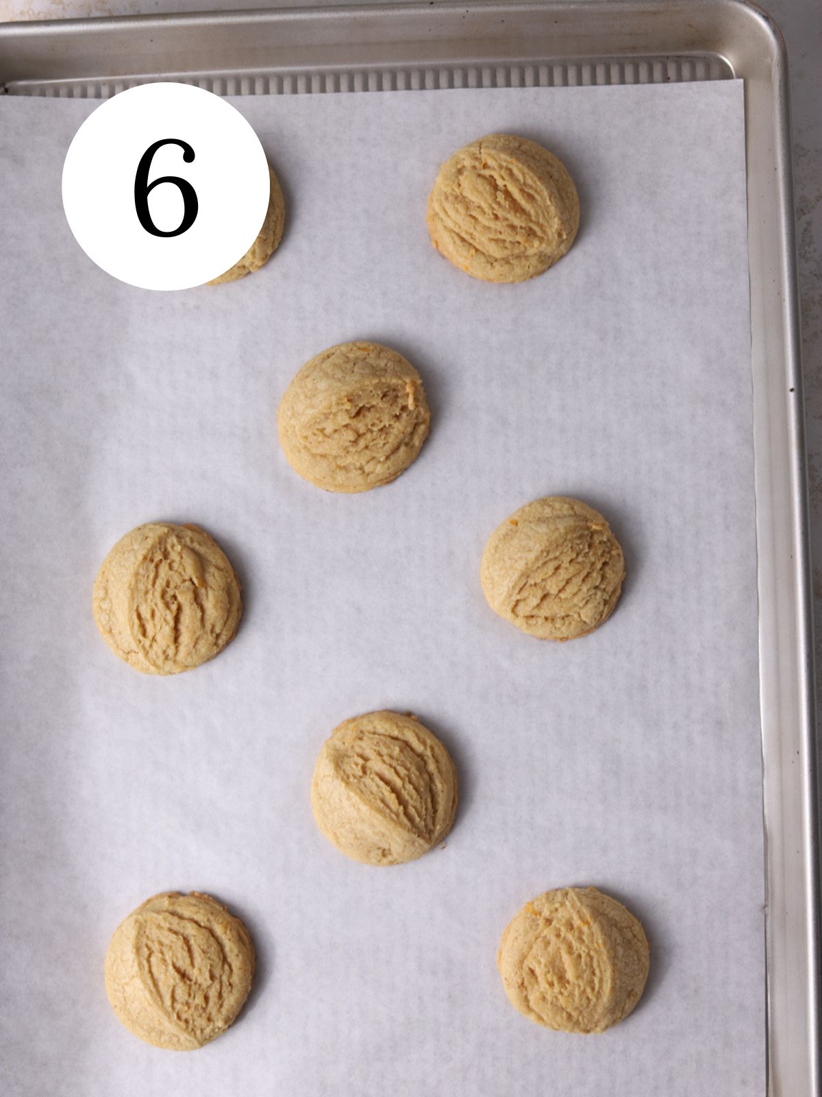 Grapefruit cookies on a baking sheet lined with parchment paper.