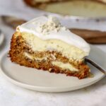 A slice of carrot cheesecake with labneh topping on a plate.