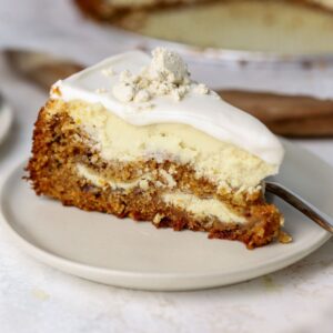 A slice of carrot cheesecake with labneh topping on a plate.