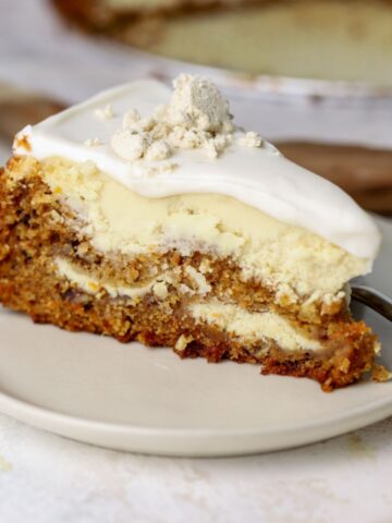 A slice of carrot cheesecake with labneh topping on a plate.