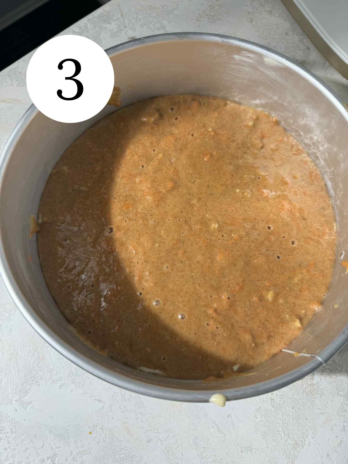 Carrot cake batter in a springform pan.