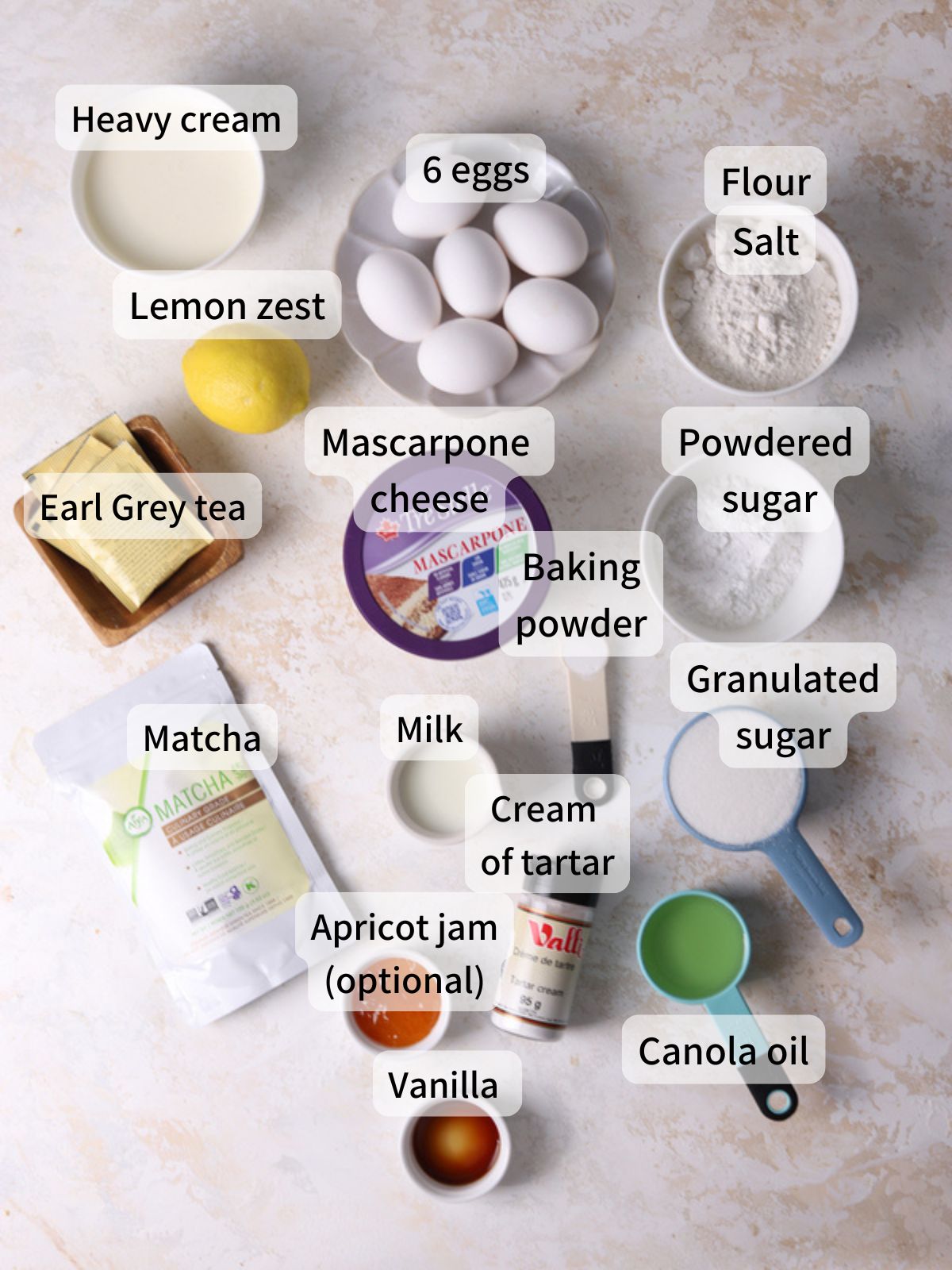 Labeled ingredients needed to make matcha roll cake laid out on a table.