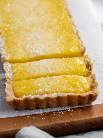 A rectangular shaped lemon tart sliced.