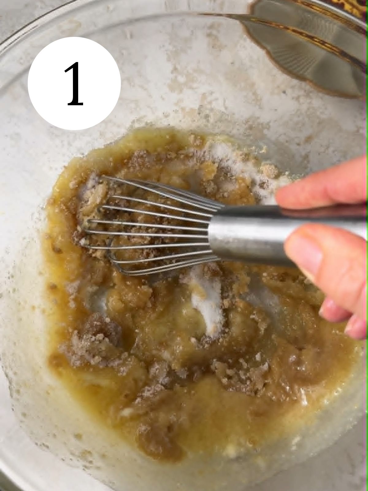 Whisking sugars and butter in a glass mixing bowl.