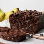 Chocolate banana bread sliced with a knife.