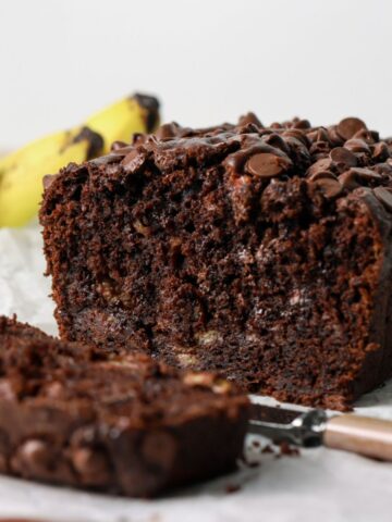 Chocolate banana bread sliced with a knife.