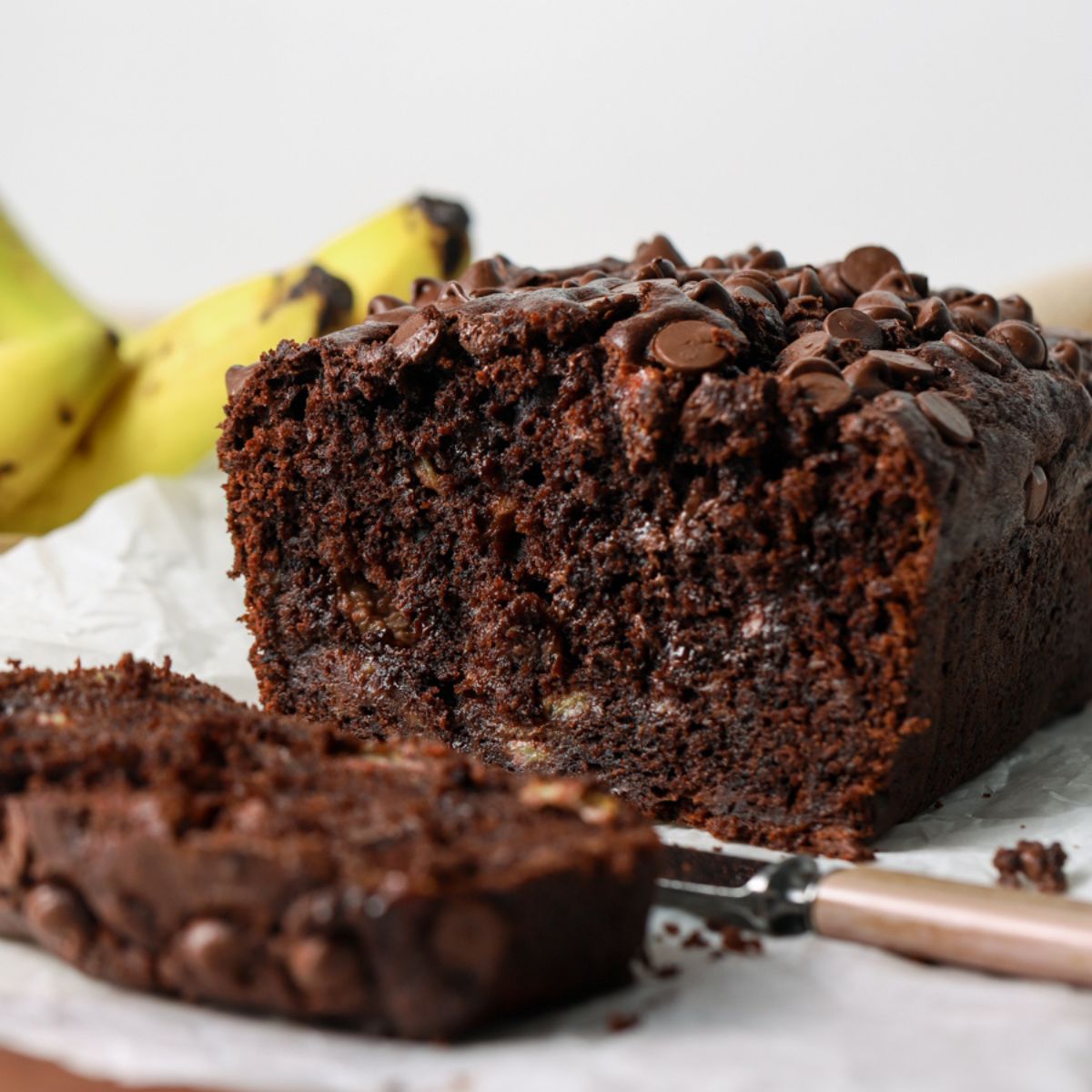Chocolate banana bread sliced with a knife.