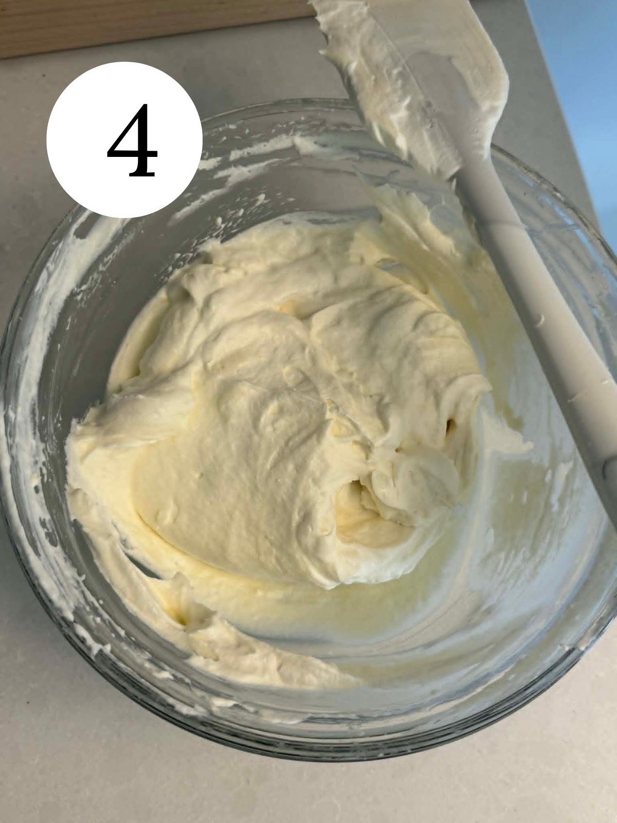 Cream cheese whipped cream in a bowl with a spatula.