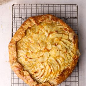 An apple tart on a cooling rack.