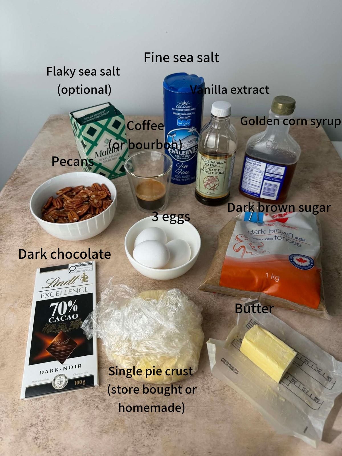 Labeled ingredients needed to make pecan and chocolate pie laid out on a table.