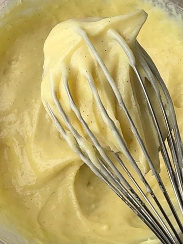 Silky vanilla pastry cream on a whisk and in a bowl.
