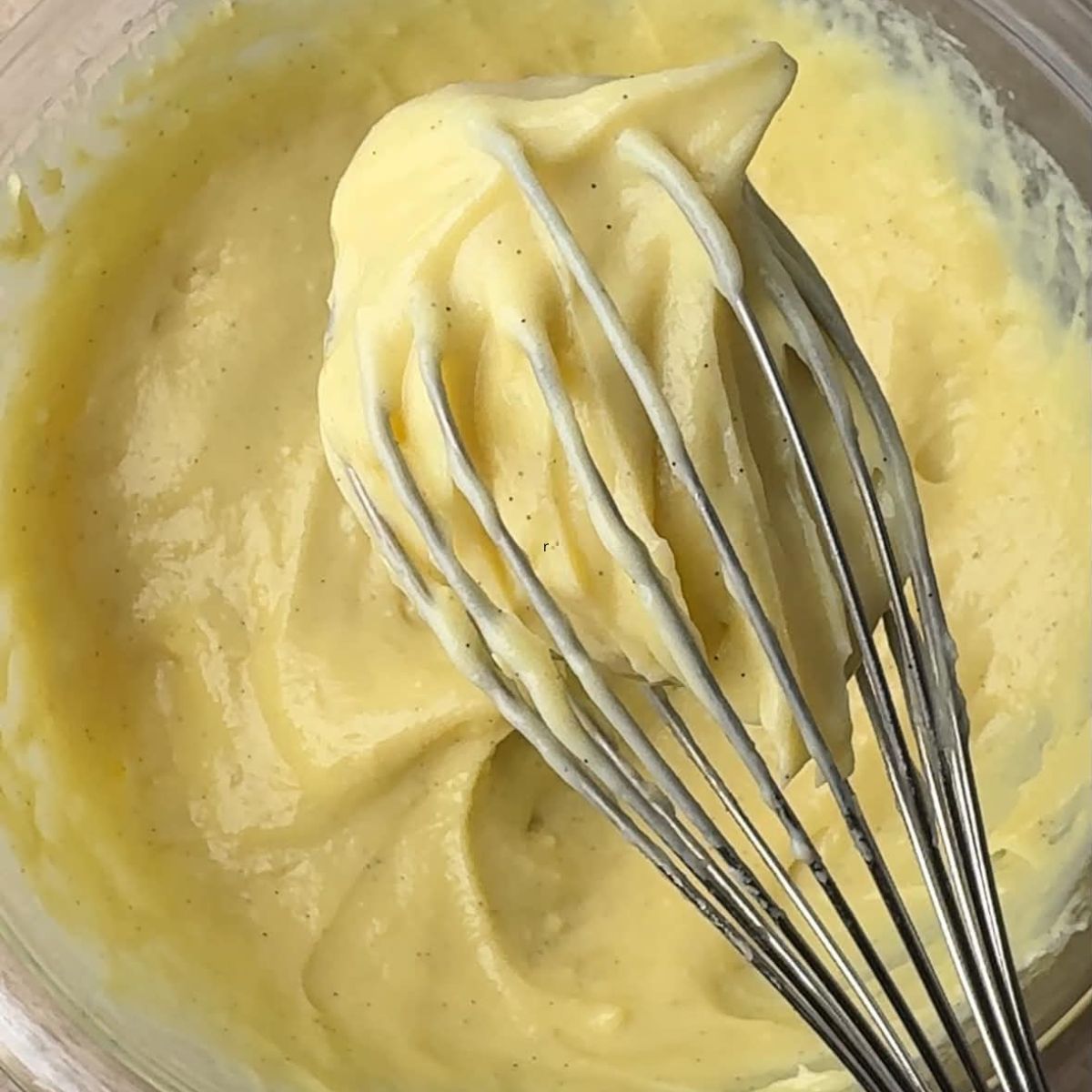 Silky vanilla pastry cream in a bowl and on a whisk.